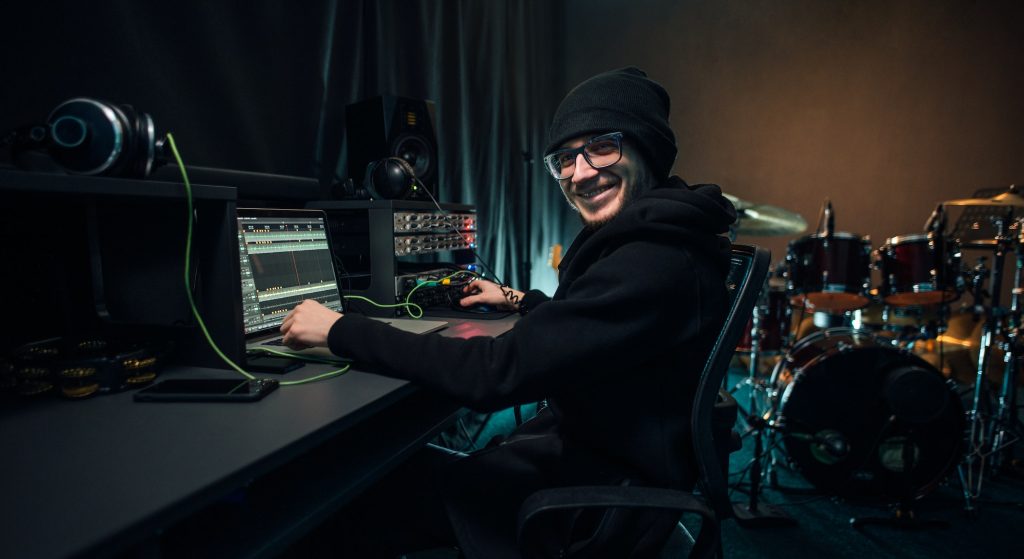 a sound engineer uses a mixing board and software to create audio track 1024x559 1